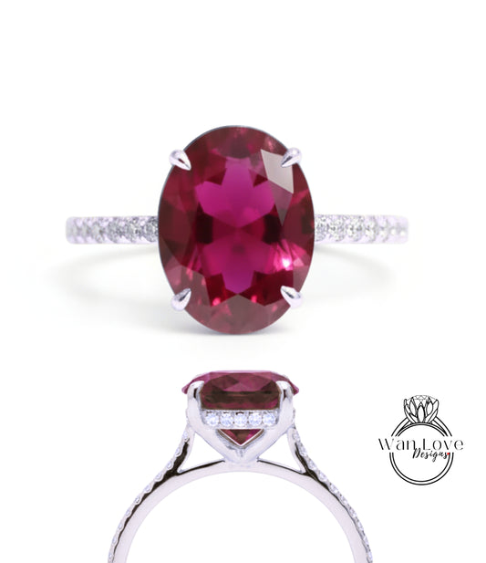 A stunning engagement ring with a large oval-shaped garnet gemstone set in a silver band adorned with small diamonds.