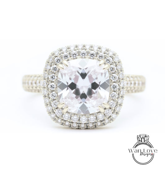 A diamond engagement ring with a large central gemstone surrounded by a halo of smaller diamonds set in a silver band.