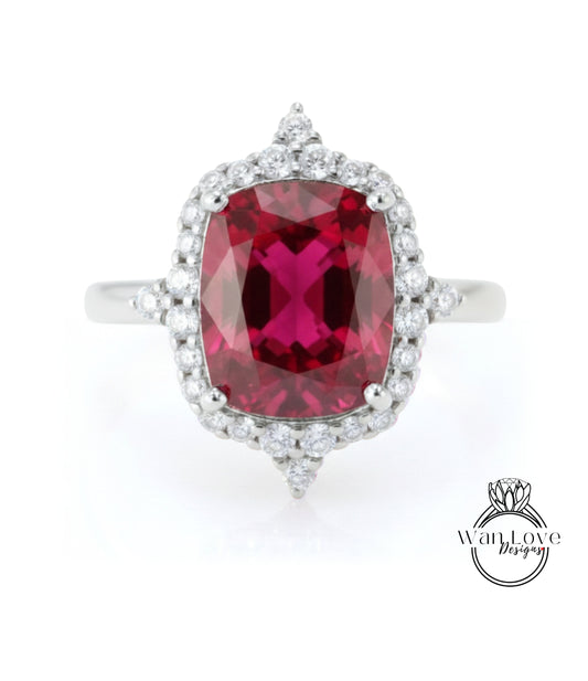 A stunning ring featuring a large, deep red gemstone surrounded by a halo of smaller diamonds, set in a silver band.