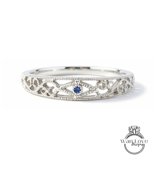A silver ring with a blue gemstone in the center, featuring an intricate, decorative design.
