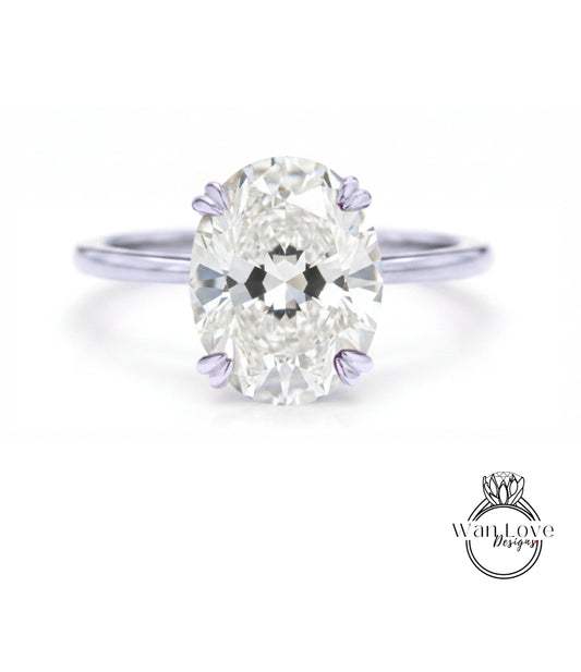 A close-up of a diamond engagement ring with a large oval-shaped diamond set in a silver band.