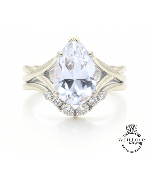 A close-up of a diamond engagement ring with a large pear-shaped gemstone set in a silver band.