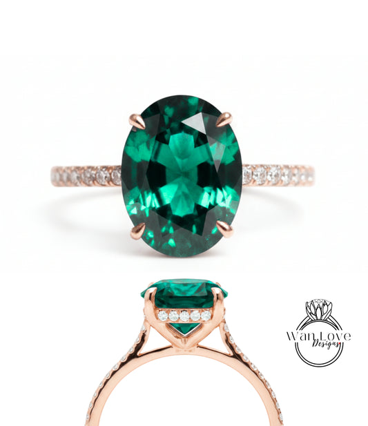 a large oval-shaped green gemstone ring with a gold band and small diamonds.