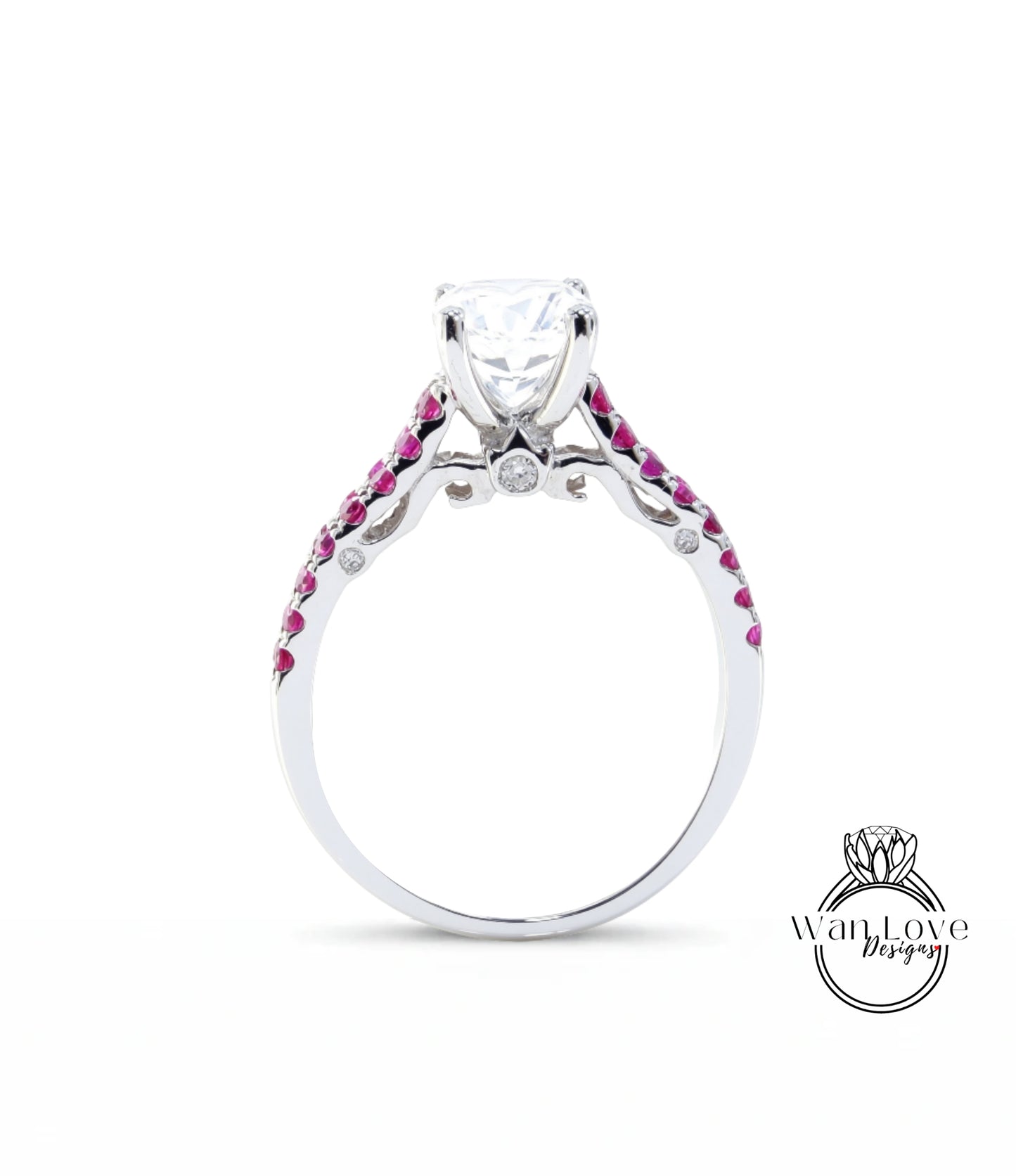 A silver engagement ring with a large central diamond and a row of smaller diamonds on either side, set in a silver band with red gemstones.