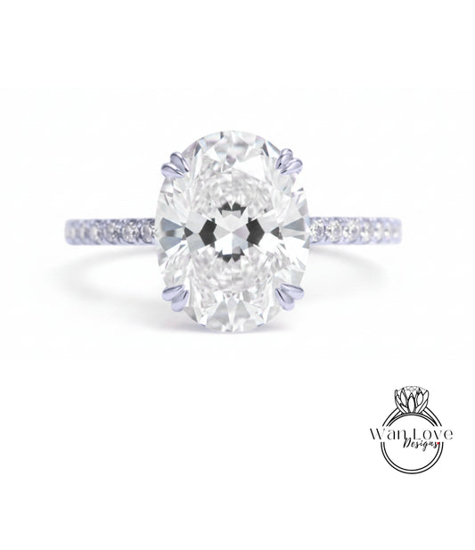 A close-up of a diamond engagement ring with a large oval-shaped diamond set in a band of smaller diamonds.