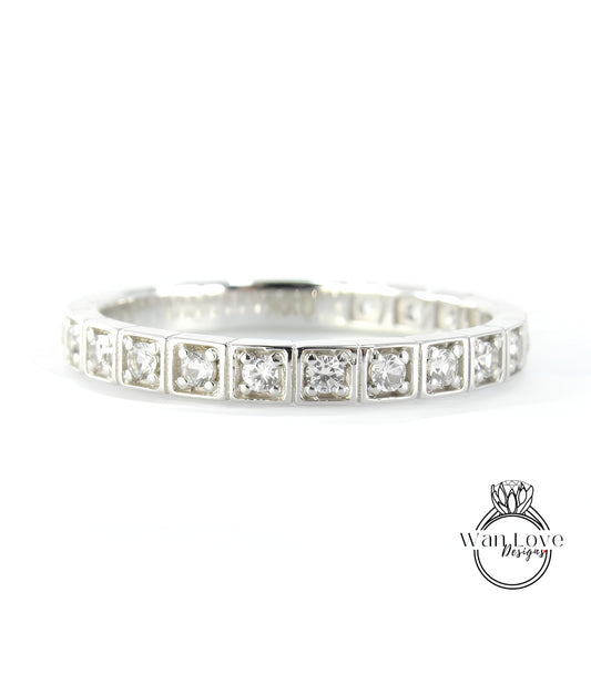 A silver band ring with a row of small diamonds set in the center.