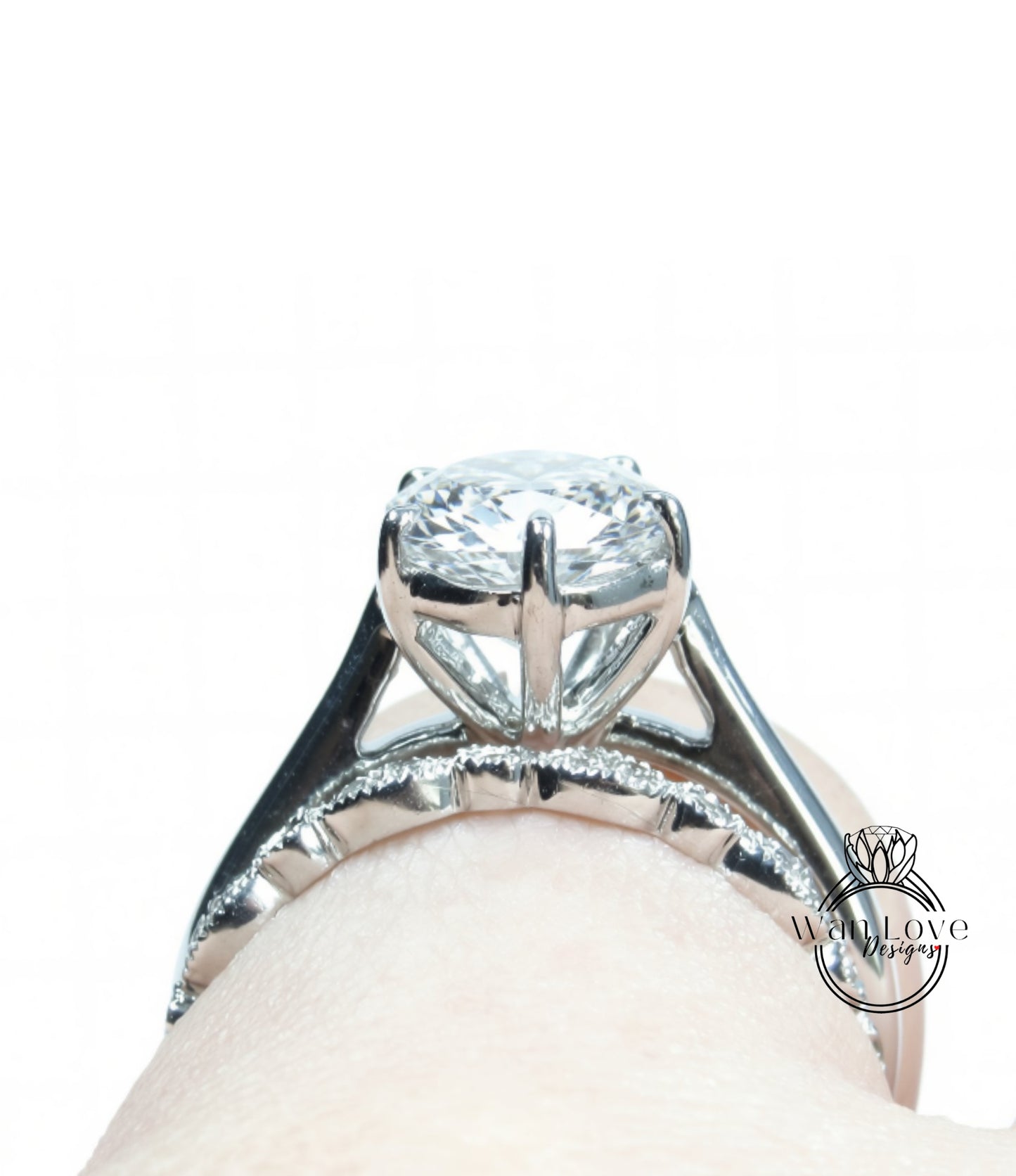 A close-up view of a diamond engagement ring on a person's hand, showcasing the intricate design and sparkling gemstone.