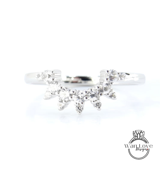 A silver ring with a large, sparkling diamond in the center, surrounded by smaller diamonds.