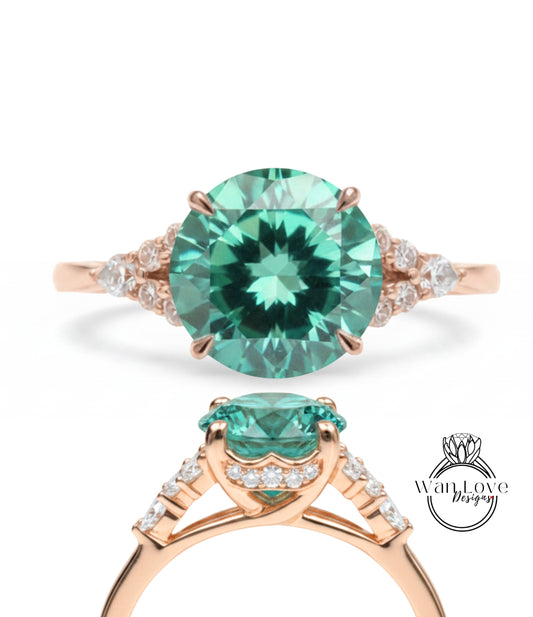 A beautiful engagement ring with a large, round green gemstone set in a rose gold band, surrounded by smaller diamonds.