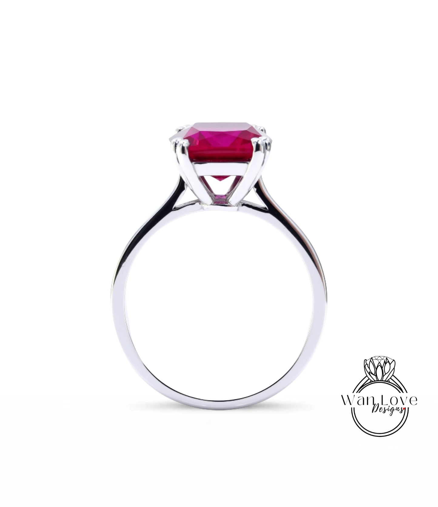 A silver ring with a large, vibrant red gemstone set in the center.