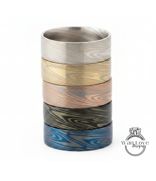 A stack of five rings with unique wood grain patterns in various colors, including silver, gold, bronze, blue, and black.
