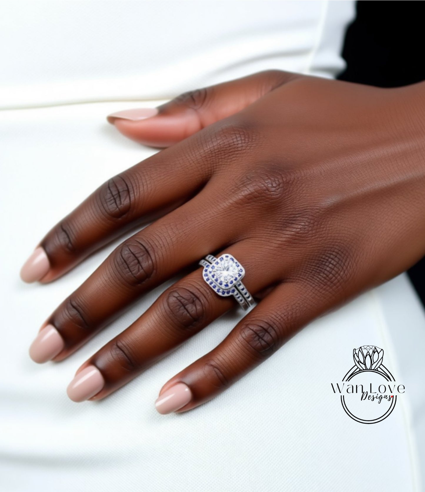 A close-up of a hand wearing a diamond engagement ring with a large central diamond surrounded by smaller diamonds.