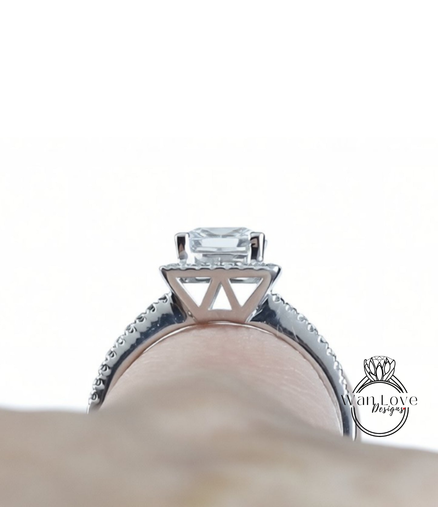 A close-up view of a diamond engagement ring on a person's finger, showcasing the intricate design and sparkling gemstone.