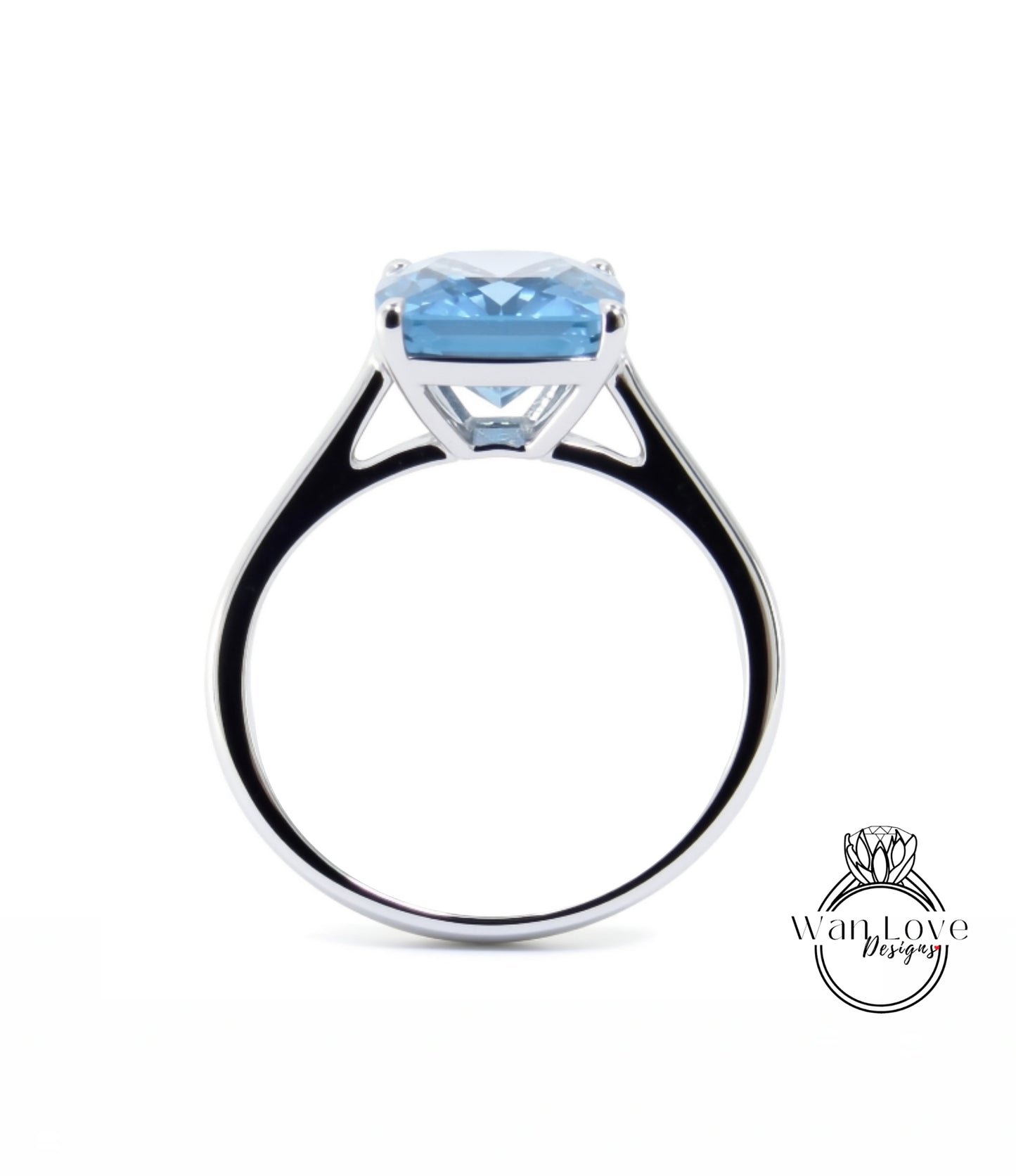 A silver ring with a large blue gemstone, likely a diamond, set in the center.