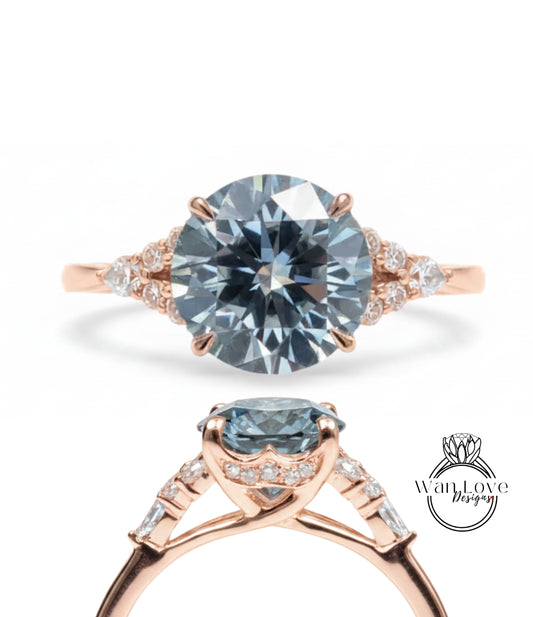a beautiful engagement ring with a large blue diamond set in a rose gold band. The ring is adorned with smaller diamonds around the band, adding to its elegance and sophistication.