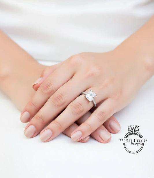 A close-up of a person's hands wearing a diamond engagement ring.