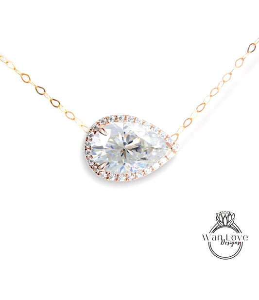 A necklace with a large, clear diamond pendant set in a gold-toned metal frame.