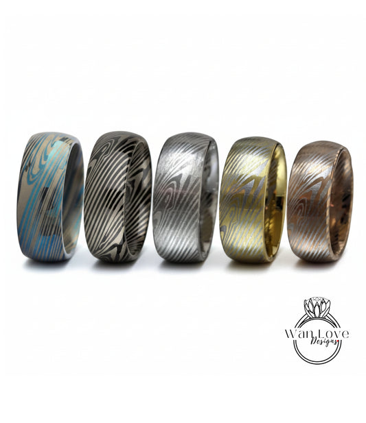 a collection of five rings with unique designs, arranged in a row against a white background.
