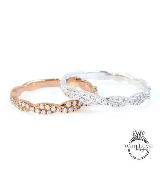 Two rings with diamonds on them, one silver and one gold, are displayed against a white background.