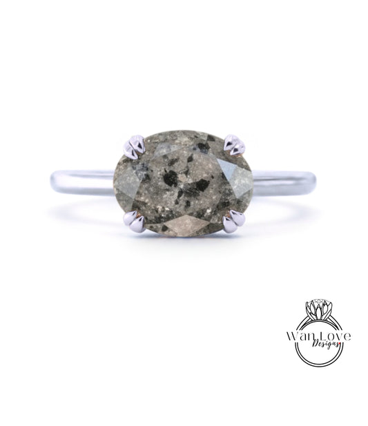 A silver ring with a large oval-shaped diamond as the centerpiece.