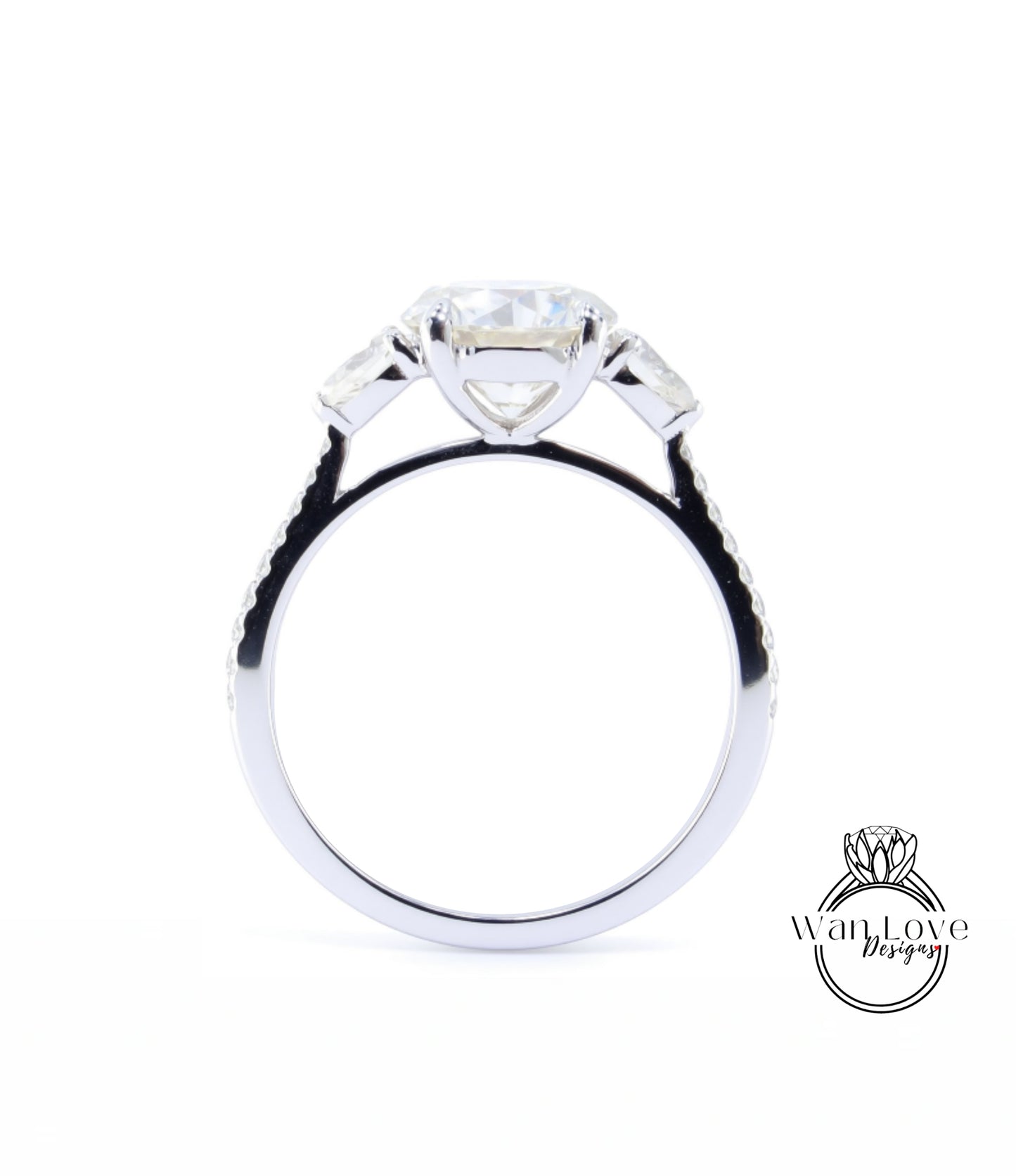 A close-up view of a silver engagement ring with a large central diamond and three smaller diamonds on either side.
