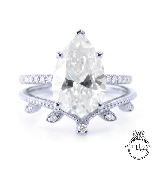 A close-up image of a diamond engagement ring with a large pear-shaped diamond set in a band with smaller diamonds.