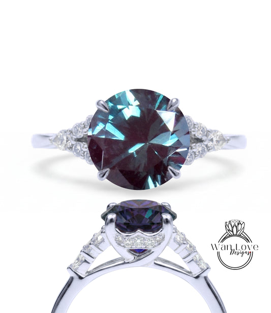 A close-up view of a silver ring with a large, dark blue gemstone set in the center. The ring has a unique design with a large, dark blue gemstone surrounded by smaller diamonds.