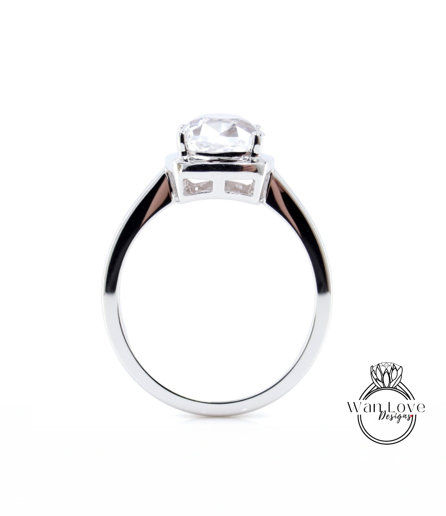 A silver engagement ring with a large, clear gemstone set in the center.