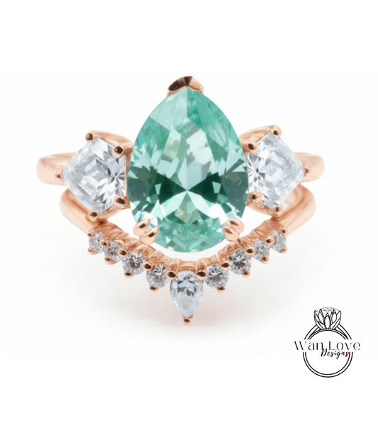 a beautiful ring with a large, green gemstone set in a rose gold band. The ring is adorned with smaller diamonds arranged in a decorative pattern around the band, creating an elegant and eye-catching design.