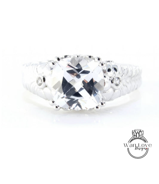A close-up view of a diamond engagement ring with a large, clear gemstone set in a silver band.