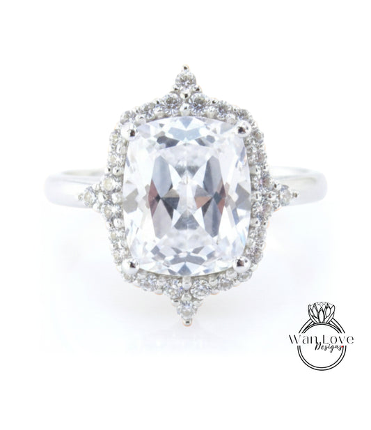 A large, clear gemstone ring with a halo of smaller diamonds around the center stone.