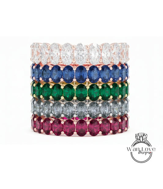 A stack of colorful rings with various gemstones, including diamonds and gemstones in different colors.