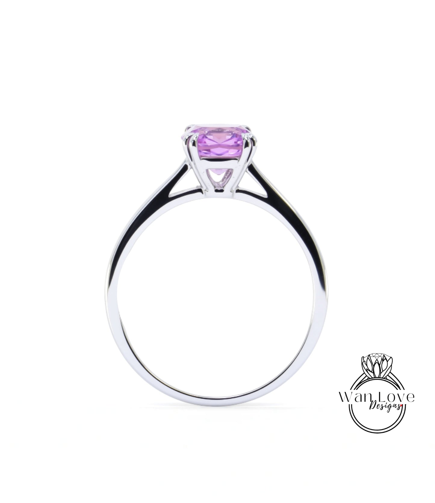 A silver ring with a large purple gemstone, likely a sapphire, set in the center.