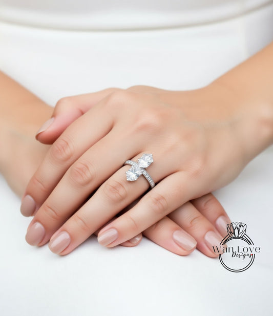 A close-up of a person's hands wearing a large, ornate ring with a large central diamond.