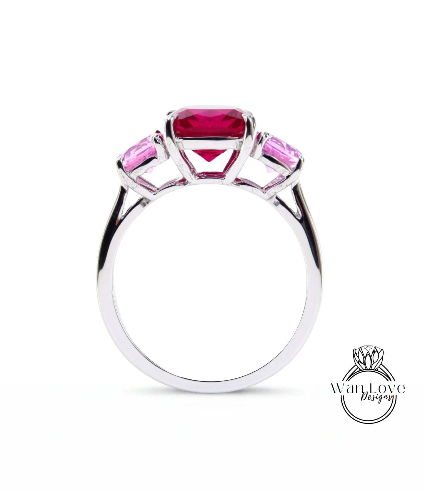 A silver ring with a large pink gemstone in the center, surrounded by smaller pink gemstones.
