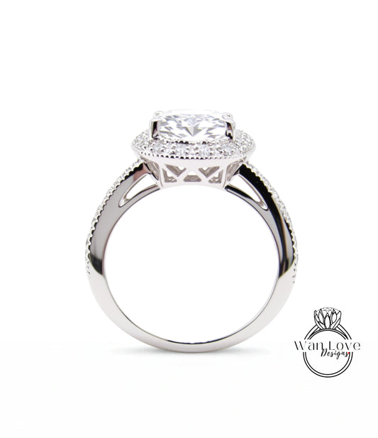 A close-up of a silver engagement ring with a large central diamond surrounded by smaller diamonds, set in a halo of smaller diamonds.
