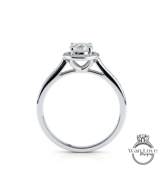 A silver engagement ring with a large central diamond and a halo of smaller diamonds around the center stone.