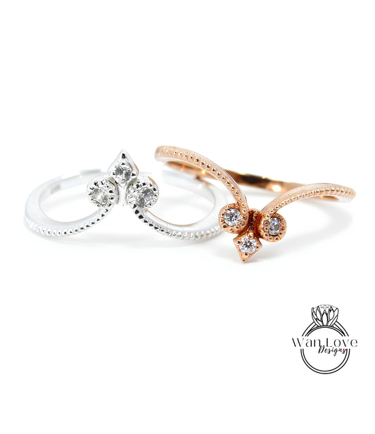 two rings with diamond-encrusted designs, one silver and one gold, against a white background.