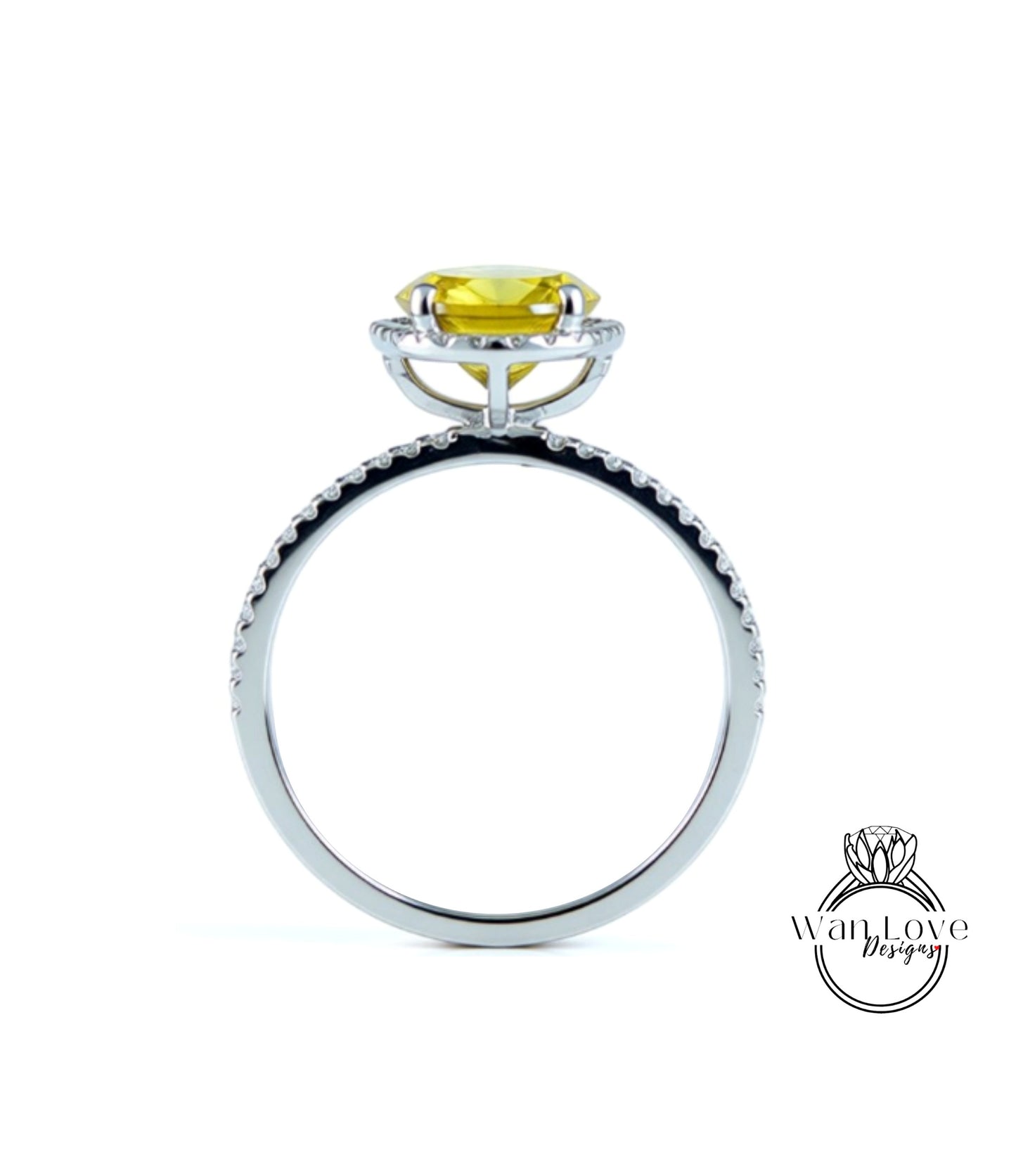 A silver ring with a yellow gemstone, possibly a diamond, set in the center.