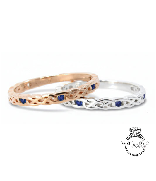 Two rings with intricate designs and blue gemstones are displayed against a white background.