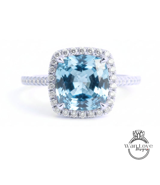 A stunning blue gemstone ring with a halo of diamonds around the center stone.