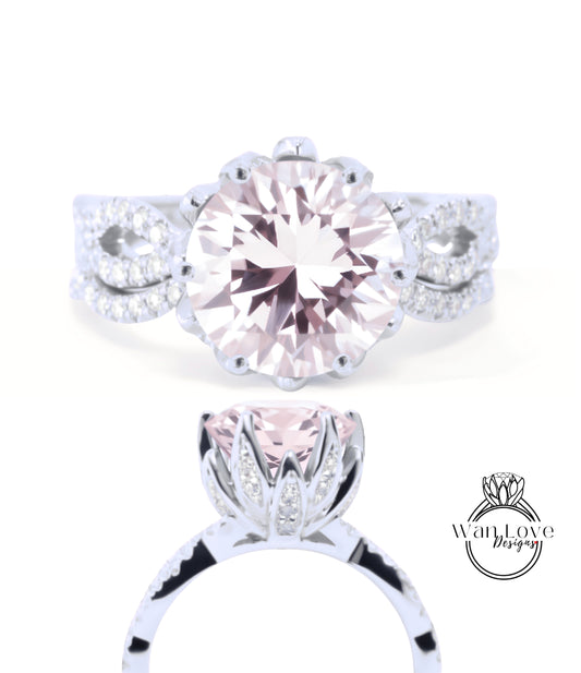 A close-up view of a beautiful pink diamond engagement ring with a large central diamond surrounded by smaller diamonds and a delicate floral design.