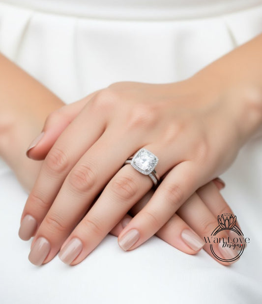 A close-up of a person's hands wearing a large diamond engagement ring.