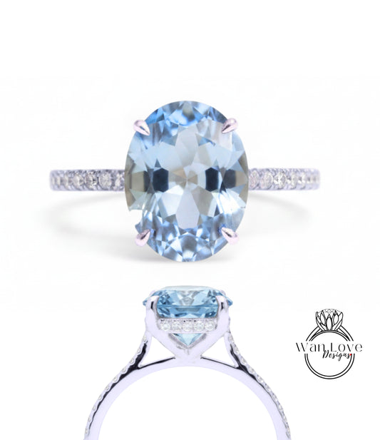 A stunning blue aquamarine gemstone engagement ring with a delicate band and sparkling diamonds.