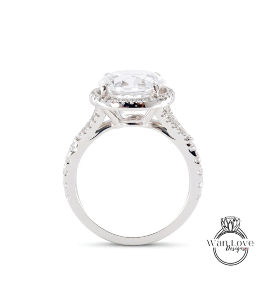A close-up view of a silver engagement ring with a large central diamond and a halo of smaller diamonds around it.