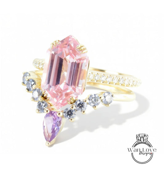 A gold ring with a large pink gemstone and smaller purple gemstones, set against a white background.