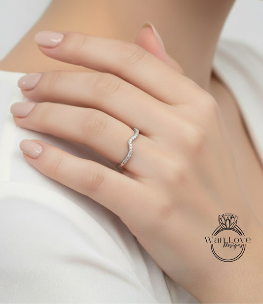 A close-up of a person's hand wearing a diamond ring on the ring finger.