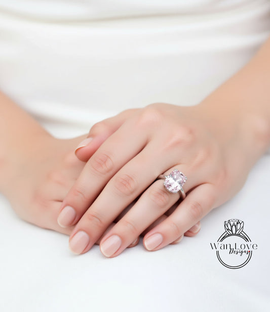 A close-up of a person's hand wearing a large, pink gemstone ring.