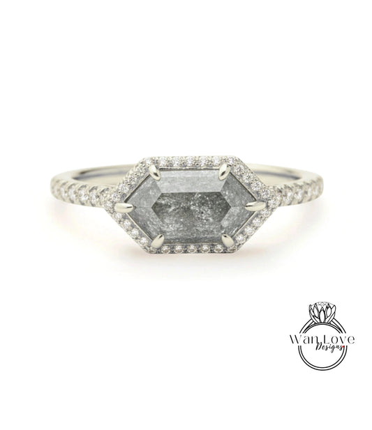 A silver ring with a large, irregularly shaped diamond as the centerpiece, surrounded by smaller diamonds.