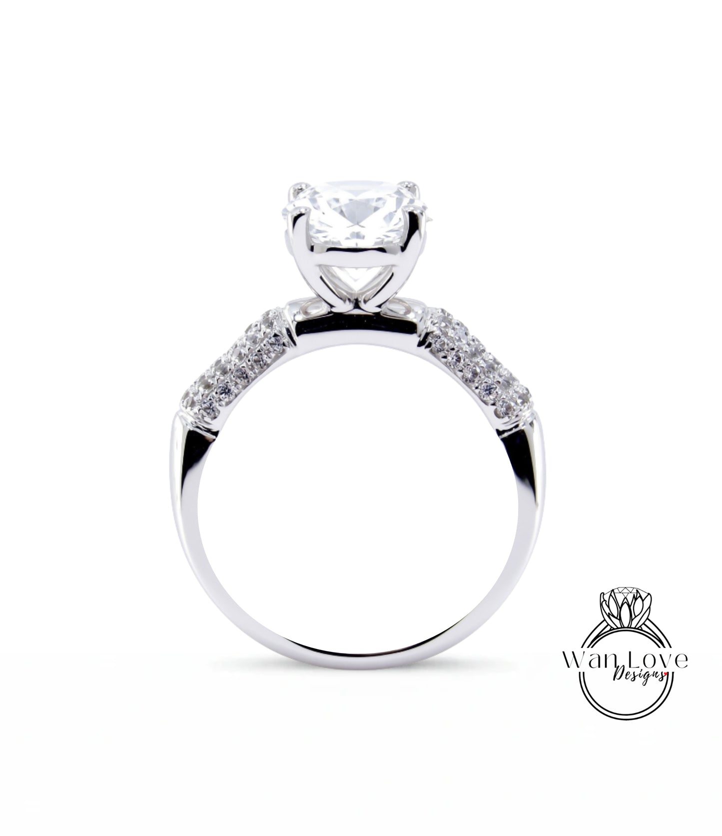 A close-up view of a silver engagement ring with a large central diamond and smaller diamonds on either side.